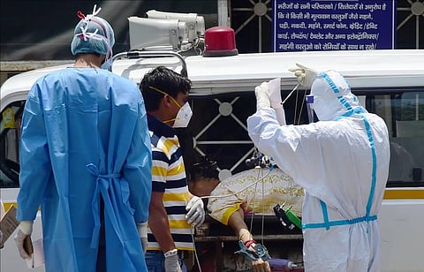 Medics wearing PPE check a COVID-19 patient upon her arrival at LNJP hospital, in New Delhi, Sunday, May 16, 2021. (Photo | PTI)