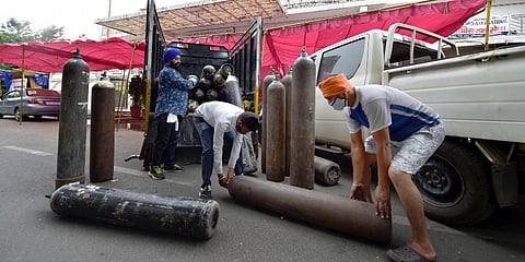 Sikh volunteers unload oxygen cylinders to support COVID-19 patients for free, at a gurudwara in Indirapuram, Ghaziabad. (Photo | PTI)