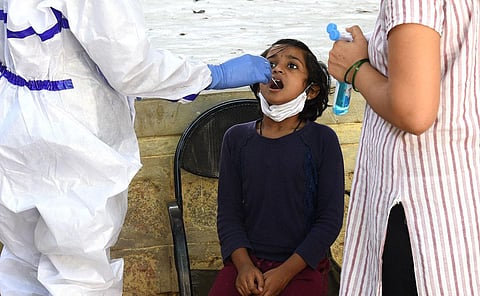 A young girl gives her swab samples for a Covid test at a Primary Health Centre in  Bengaluru. (Photo | Vinod Kumar T, EPS)
