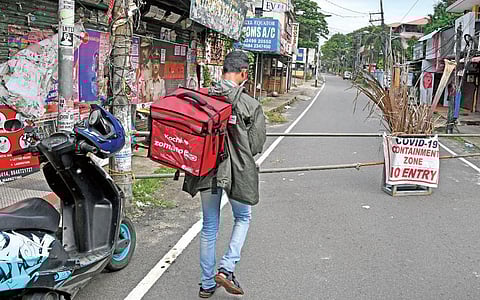 A delivery boy stops on Azad Road, Kochi, at a police barricade. He had to leave his two-wheeler and walk to the customer | Albin Mathew