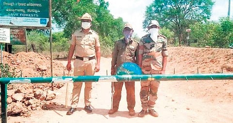 Forest  Department personnel of Karnataka man a check-post on the Karnataka and Tamil Nadu border to stop people from entering the state | Express