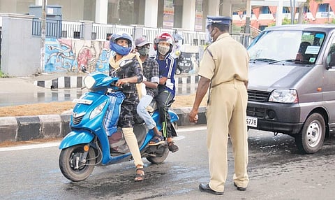 A police officer on Wednesday stopping a woman who was travelling with her two children despite the travel ban imposed as part of triple lockdown in Kochi | A Sanesh