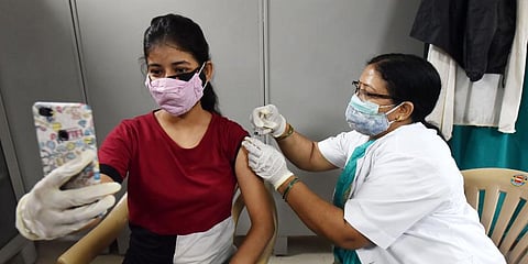 A medic administers the dose of vaccine to a beneficiary, at Moti Lal Nehru Medical College vaccination in Prayagraj. 