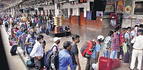Migrants arriving from Maharashtra wait for Covid tests at Patna station. (Photo | PTI)