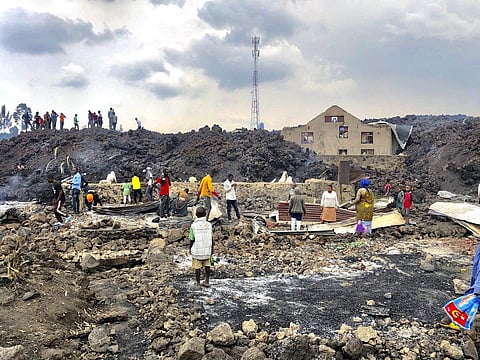 People gather on a stream of cold lava rock following the overnight eruption of Mount Nyiragongo in Goma, Congo, Sunday, May 23, 2021. (Photo | AP)