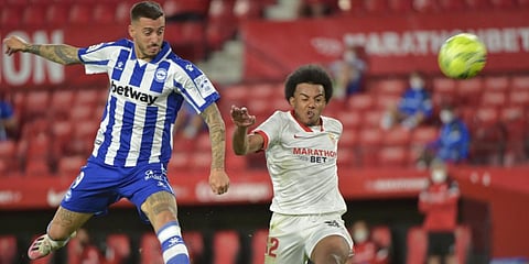 Alaves' Spanish forward Joselu (L) jumps for the ball with Sevilla's French defender Jules Kounde during a Spanish League football match. (Photo| AFP)