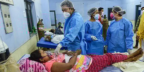 Doctors attend a COVID-19 positive patient at a makeshift hospital in Ghaziabad. (Photo | PTI)