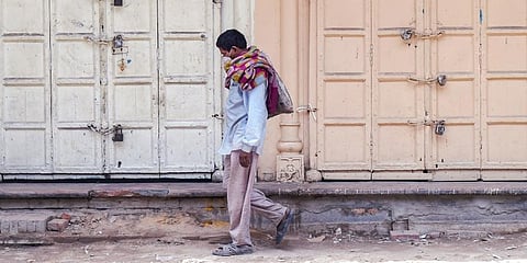 A man walks past closed shops at Chawri Bazar area during the COVID-induced lockdown, in Delhi. (Photo | PTI)