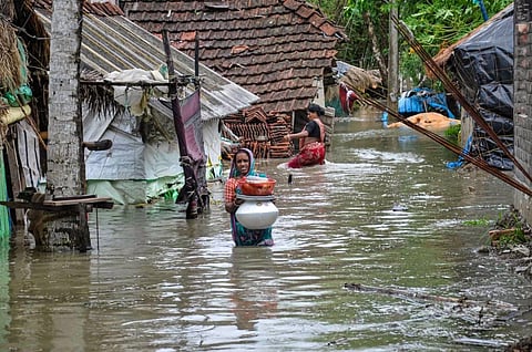 A woman wades through a water-logged road in a village after landfall of cyclone Yaas, in South 24 Paragnas. (Photo | PTI)