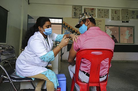 A health worker inoculates a man against the coronavirus at a vaccination camp for those above age 45 being held in the premises of a school in Bengaluru. (Photo | AP)