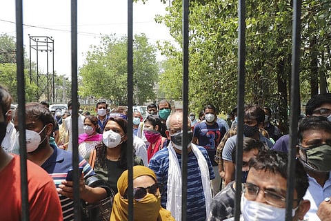 In this May 10, 2021, file photo, people waiting to get vaccinated against the coronavirus stand outside the closed gates of a hospital in Ghaziabad, outskirts of New Delhi, India. (Photo | AP)