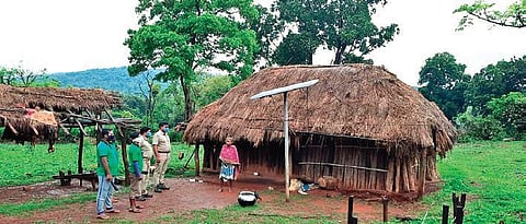 Police officials and volunteers check on a villager staying inside Similipal | Express