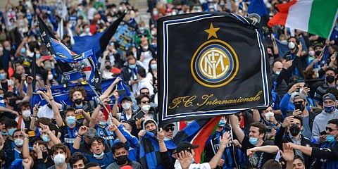 Inter Milan fans celebrate with flares and shout slogans in Piazza Duomo square in front of the gothic cathedral after Inter Milan won its first Serie A title in more than a decade. (Photo | AP)