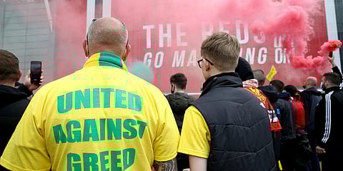 A fan wears a shirt with a 'United Against Greed' message, as fans gather to protest against the Glazer family, the owners of Manchester United, outside Old Trafford stadium. (Photo| AP)