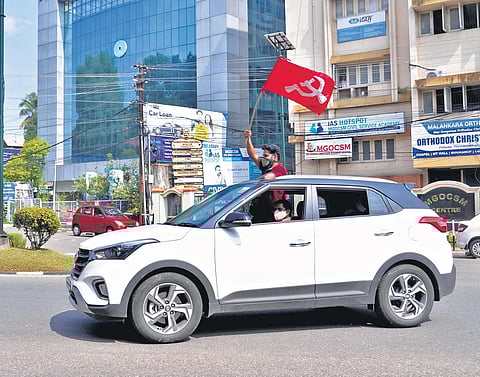 A CPM worker waves the party’s flag in front of AKG Centre to celebrate the LDF’s historic win in Thiruvananthapuram on Sunday | Vincent Pulickal