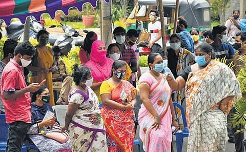 People stand in a queue to get themselves tested for coronavirus at Tummalapalli Kalashetram in Vijayawada on Saturday. (Photo I EPs/Prasant Madugula)