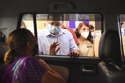 Delhi Chief Minister Arvind Kejriwal interacts with a beneficiary as he visits a drive-through COVID vaccination centre, at Chhatrasal Stadium in New Delhi. (Photo | PTI)