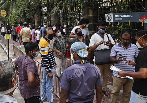People line up to receive vaccine for COVID-19 outside a vaccination centre in Mumbai. (Photo | AP)