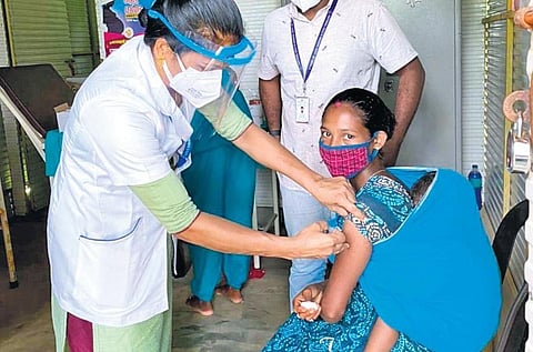 Health workers vaccinating a tribal woman at Uriyampetti tribal colony in Kuttampuzha forest on Friday