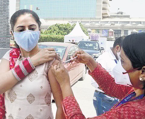 A woman gets jab at a drive-through vaccination centre in Delhi on Sunday. (Photo | Parveen Negi/EPS)