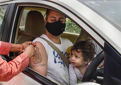 A health worker administers a dose of COVID-19 vaccine to a beneficiary at a drive-through vaccination camp, at Saket in New Delhi, Sunday, May 30, 2021. (Photo | PTI)