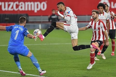Sevilla's Moroccan forward Youssef En-Nesyri (C) challenges Athletic Bilbao's Spanish goalkeeper Unai Simon during the Spanish League football match (Photo | AFP)