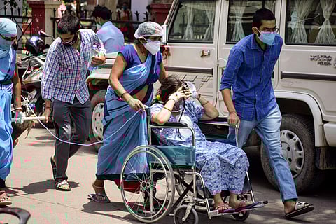 Relatives carry a COVID-19 positive patient on oxygen support to a hospital. (Representational photo | PTI)