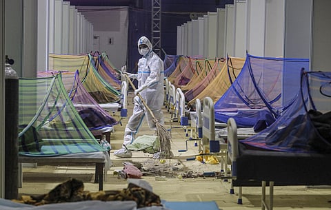 A worker, wearing PPE kit, does cleaning works at the COVID Care Centre at Commonwealth Games Village, in New Delhi. (Photo | PTI)