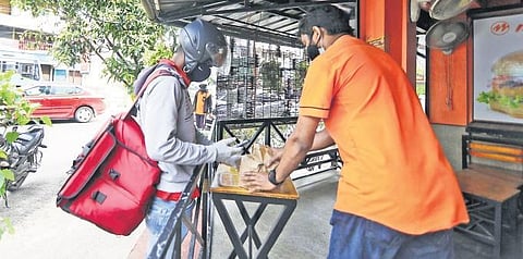A delivery executive collecting food from a restaurant in the city | ARUN ANGELA