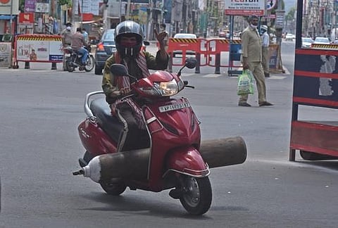 A biker takes an oxygen cylinder to a patient, in Vijayawada on Friday | P Ravindra Babu
