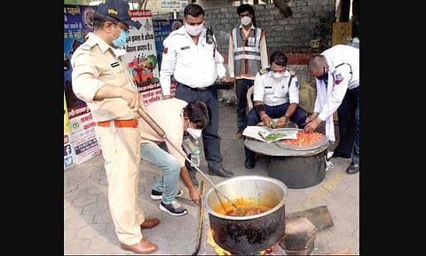 Madhya Pradesh's ‘Moonwalk’ cop Ranjeet Singh and his collegues cook food at the traffic police station. (Photo | EPS)