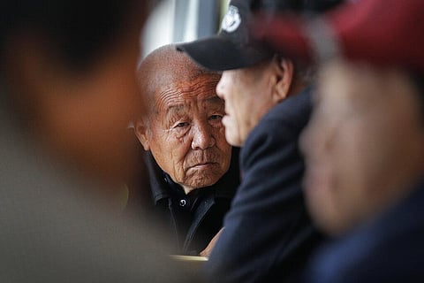 Elderly people take a seat at Kang's canteen, the Harmonious and Happy Home for free vegetarian lunch in Dingxing, southwest of Beijing. (Photo | AP)