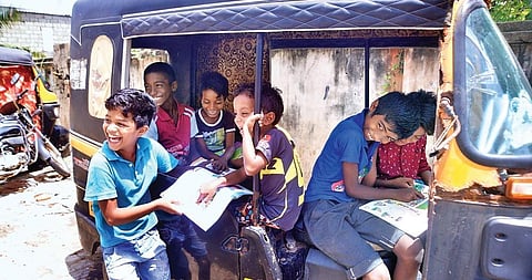 Inmates of a sea erosion relief camp in Thiruvananthapuram going through their new textbooks a day before the beginning of online classes, in an autorickshaw. (Photo | Vincent Pulickal, EPS)