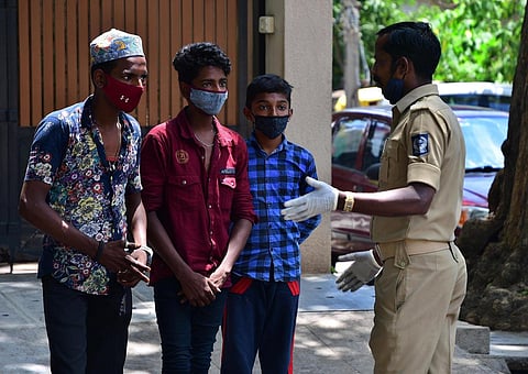 A home guard warns children against roaming outside during the lockdown in Bengaluru on Monday. (Photo | Ashishkrishna HP, EPS)