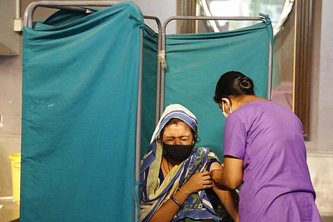 A woman reacts as she receives a dose of Covishield, the Oxford-AstraZeneca vaccine for COVID-19, in Ahmedabad. (Photo | AP)