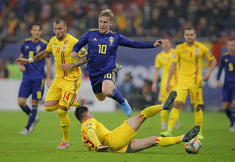 Sweden's Emil Forsberg. top, is tackled by Romania's Tudor Baluta during the Euro 2020 group F qualifying soccer match between Romania and Sweden. (Photo | AP)
