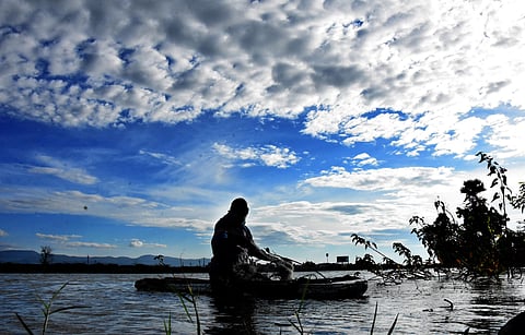 A fisherman rowing a boat to catch fish in a lake. (Photo | Madhav, EPS)