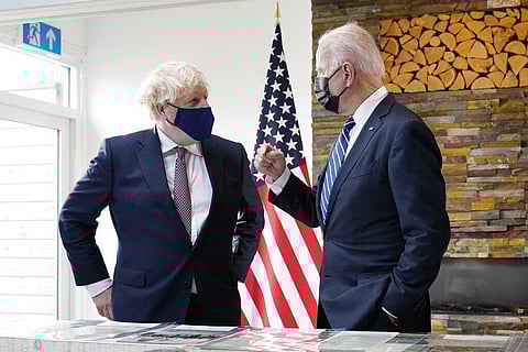 President Joe Biden and British Prime Minister Boris Johnson talk as they look over copies of the Atlantic Charter, during a bilateral meeting ahead of the G-7 summit. (Photo | AP)