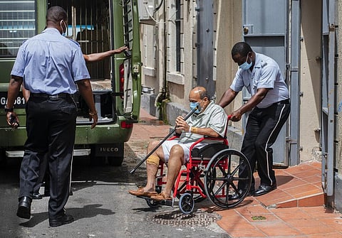 Antigua and Barbuda businessman Mehul Choksi is taken to a police van via a wheelchair by a police officer. (Photo | AP)