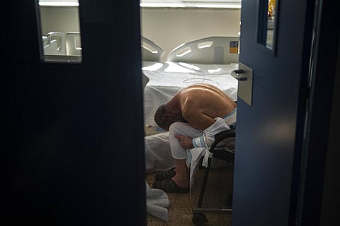 A patient infected with Coronavirus rests in a chair inside an isolated room at the COVID-19 ward of a public hospital in Barcelona, Spain. (Photo | Emilio Morenatti, AP)