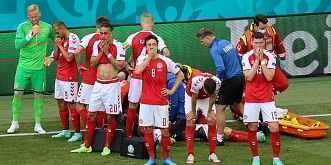 Denmark's players react as their teammate Christian Eriksen lays injured on the ground during an Euro 2020 match in Copenhagen. (Photo| AP)