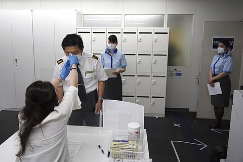 Flight crews of All Nippon Airlines line up for the workplace vaccination in its office space in Haneda Airport in Tokyo, on Sunday, June 13, 2021. (Photo | AP)