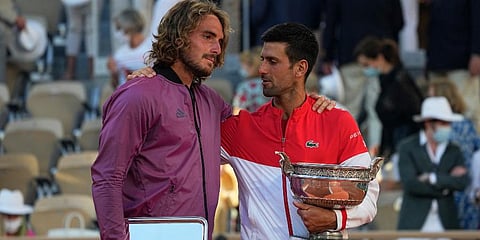 Novak Djokovic (R) and Stefanos Tsitsipas hug while holding their trophies after their final match of the French Open tennis tournament at the Roland Garros stadium. (Photo | AP)