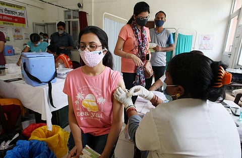 A  health worker administers a dose of a COVID-19 vaccine to a woman at a Railway hospital in Prayagraj. (File photo| PTI)