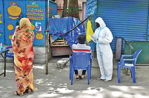 A health worker collects swab samples of a man in Bengaluru on Wednesday. The city reported 2,395 fresh Covid-19 cases. (Photo | Shriram BN, EPS)