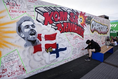 People writing well wishes at a graffiti for Danish player Christian Eriksen on a wall at the fanzone in Copenhagen. (Photo | AP)
