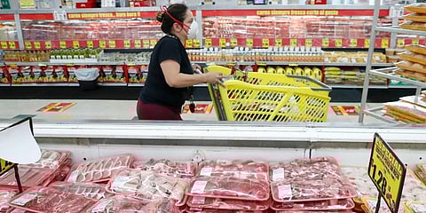 A shopper wears a mask as she walks through the meat products at a grocery store in Dallas. (Photo | AP)