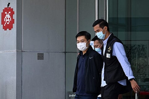 Apple Daily editor-in-chief Ryan Law is escorted by police to a waiting vehicle outside the entrance of the Apple Daily newspaper offices in Hong Kong on June 17, 2021. (Photo | AP)