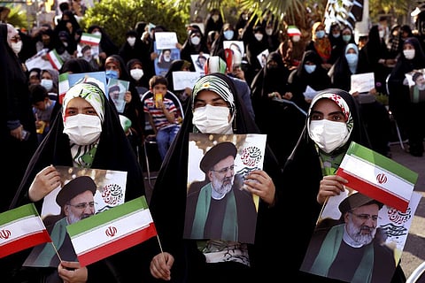 PreviousNext Supporters of presidential candidate Ebrahim Raisi hold signs during a rally in Tehran. (Photo | AP)