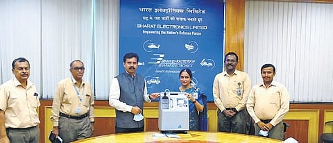 Anandi Ramalingam, Director (Marketing) BEL, hands over an oxygen concentrator donated by IAI to BEL Director (HR) Shivakumaran K M at the PSU’s corporate office in Bengaluru, in the presence of senio